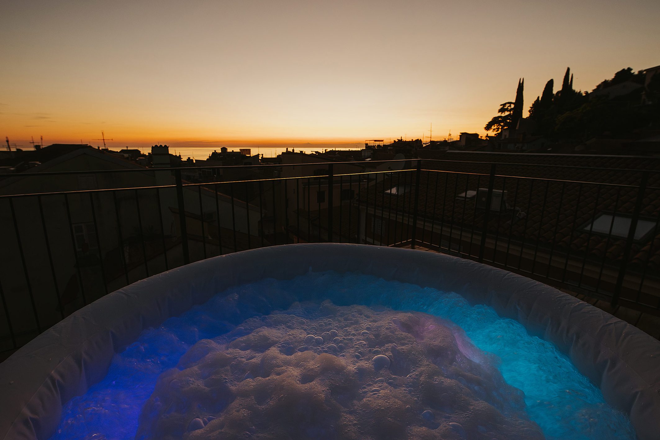 Jacuzzi na terasi s pogledom na morje ob mraku
